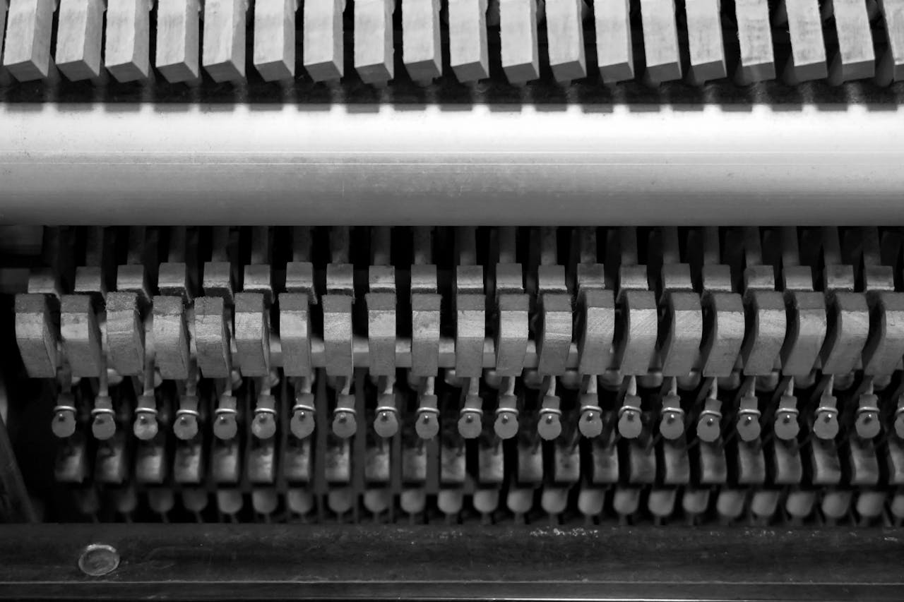 Detailed black and white image showcasing the intricate hammers and strings inside a piano.