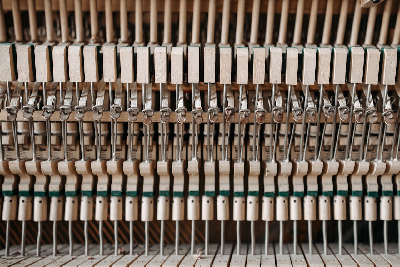 Detailed close-up of piano action mechanism showing hammers and strings.