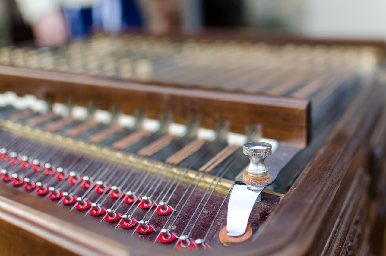 Detailed view of a dulcimer musical instrument showcasing its strings and knobs indoors.